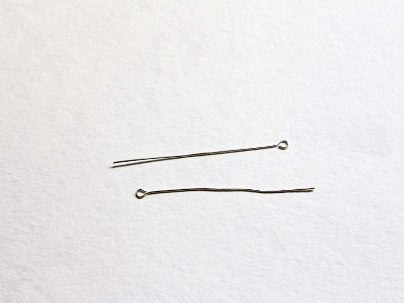 Two silver colored eye pins.