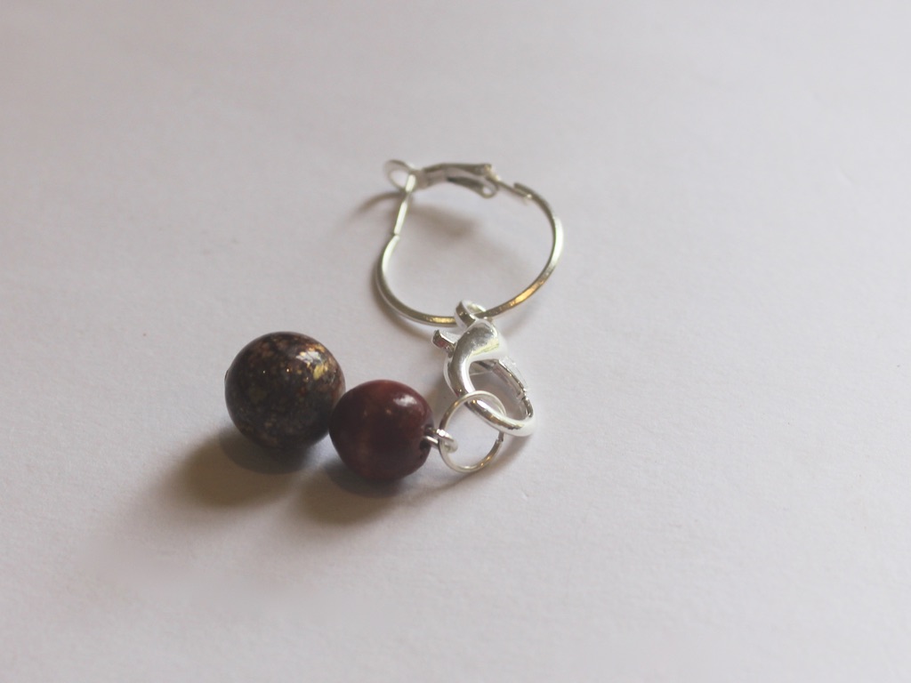 bead charm attached to one earring with clasp