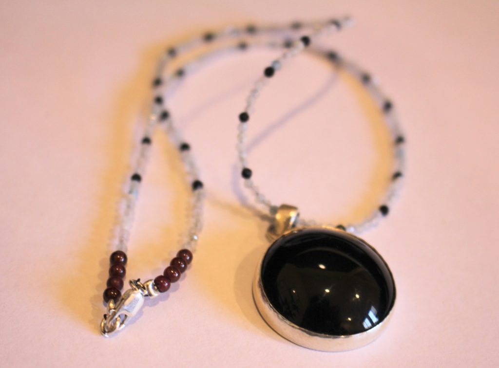 another version with a round black pendant.