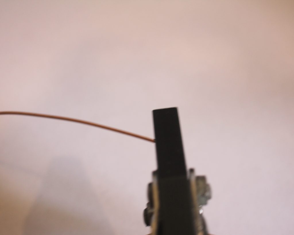 holding wire in jaws of flat nose pliers